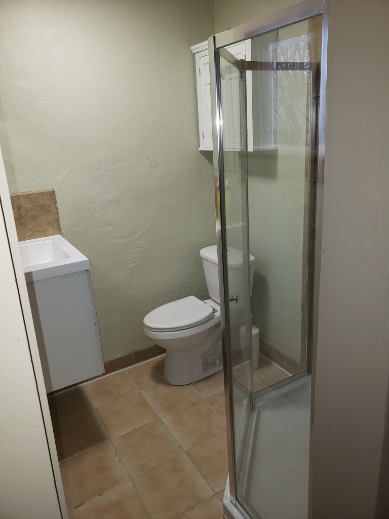 Remodeled bathroom with a glass-enclosed shower, white toilet and floating vanity