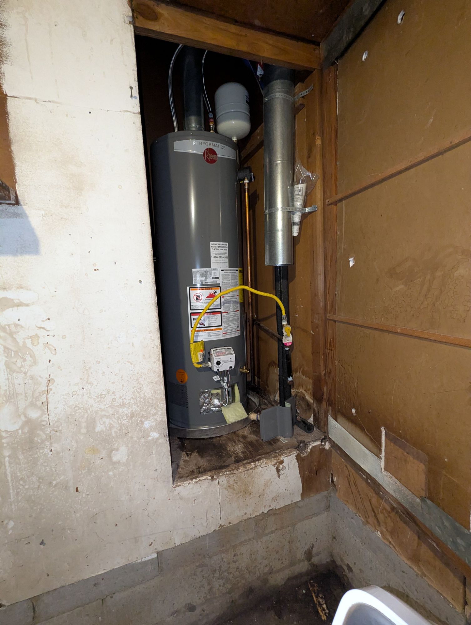 Real water heater installation and surrounding utility connections photographed at a service property